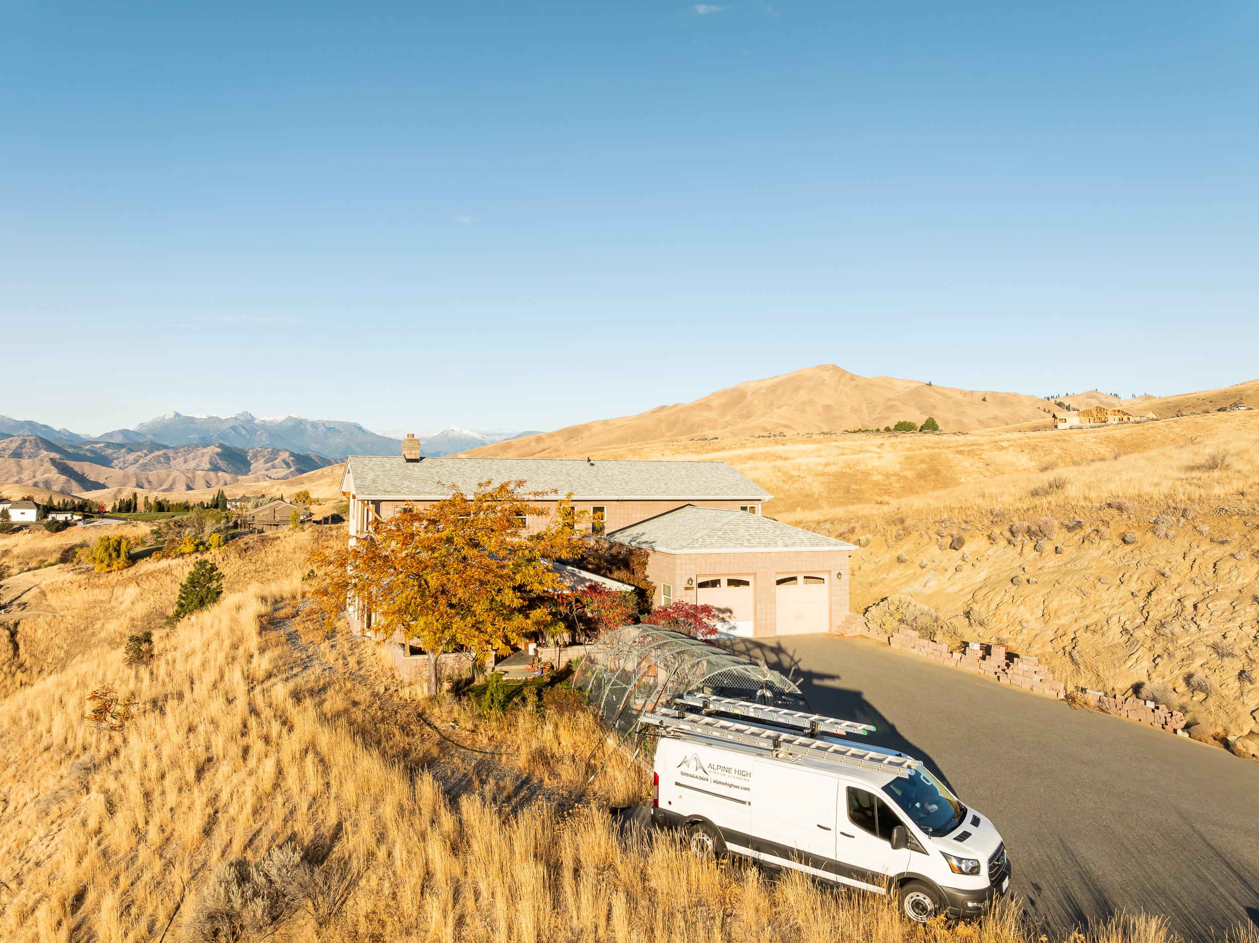 View Alpine High Window Cleaning_Fall Photography_Claridge Media-36 Aerial view of a work van for Alpine High Window Cleaning with the cascade mountains in the background.